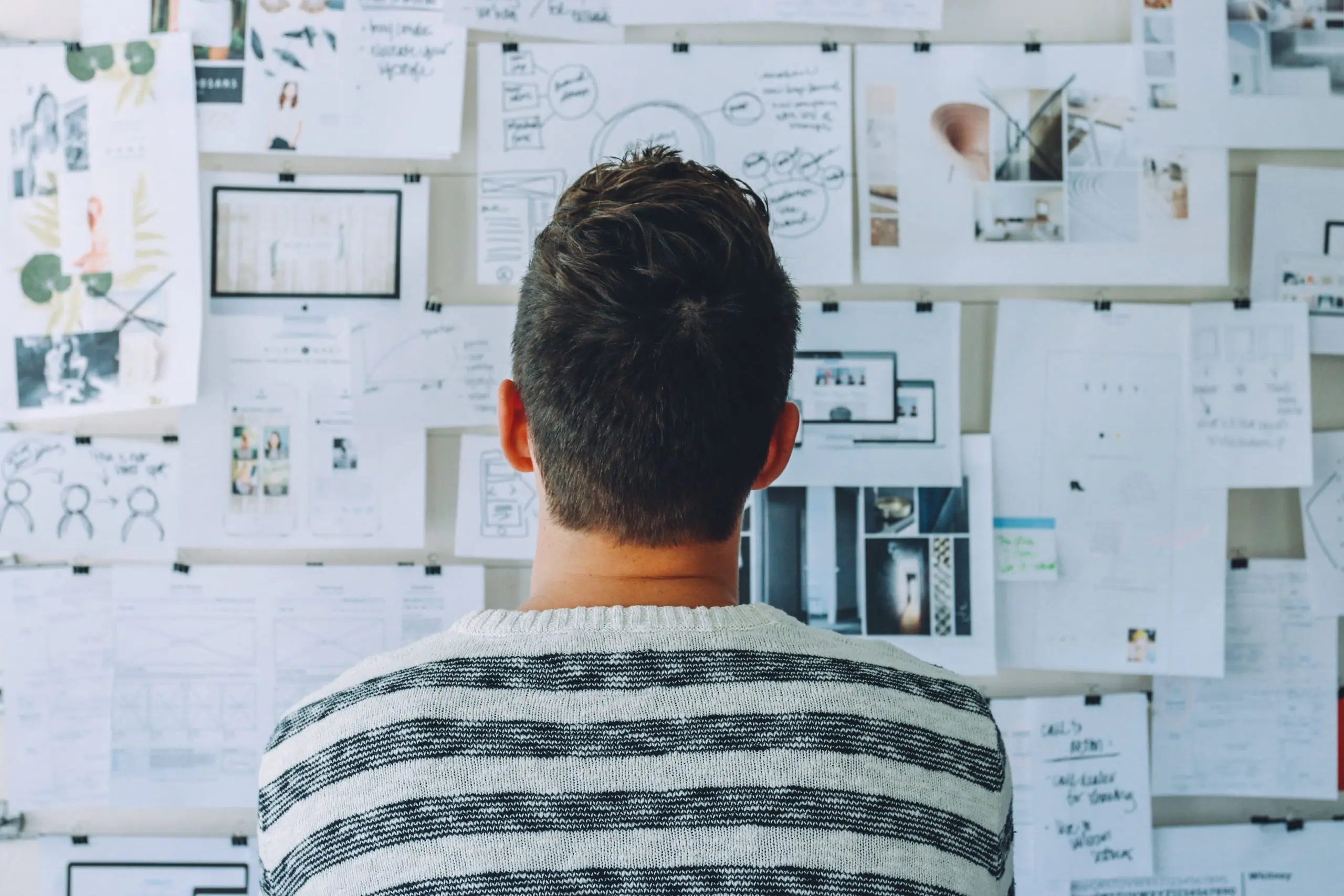 Man looking at a pin-board of ideas